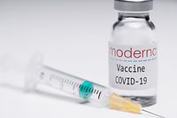 This illustration picture taken in a studio in Paris on November 16, 2020, shows a syringe and a vial with the logo of US biotech firm Moderna. - Moderna on November 16, 2020 announced its experimental vaccine against Covid-19 was almost 95 percent effective, marking a second major breakthrough in the quest to end the pandemic. (Photo by JOEL SAGET / AFP)