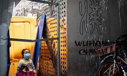 A girl wearing a face mask crosses a barricade in Wuhan, China's central Hubei province on April 7, 2020. - Wuhan, the central Chinese city where the coronavirus first emerged last year, partly reopened on March 28 after more than two months of near total isolation for its population of 11 million. (Photo by NOEL CELIS / AFP)