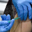 A woman receives an injection with the Pfizer-BioNTech Covid-19 disease vaccine at the regional coronavirus vaccination centre in Ludwigsburg, southern Germany, on January 22, 2021. (Photo by THOMAS KIENZLE / AFP)