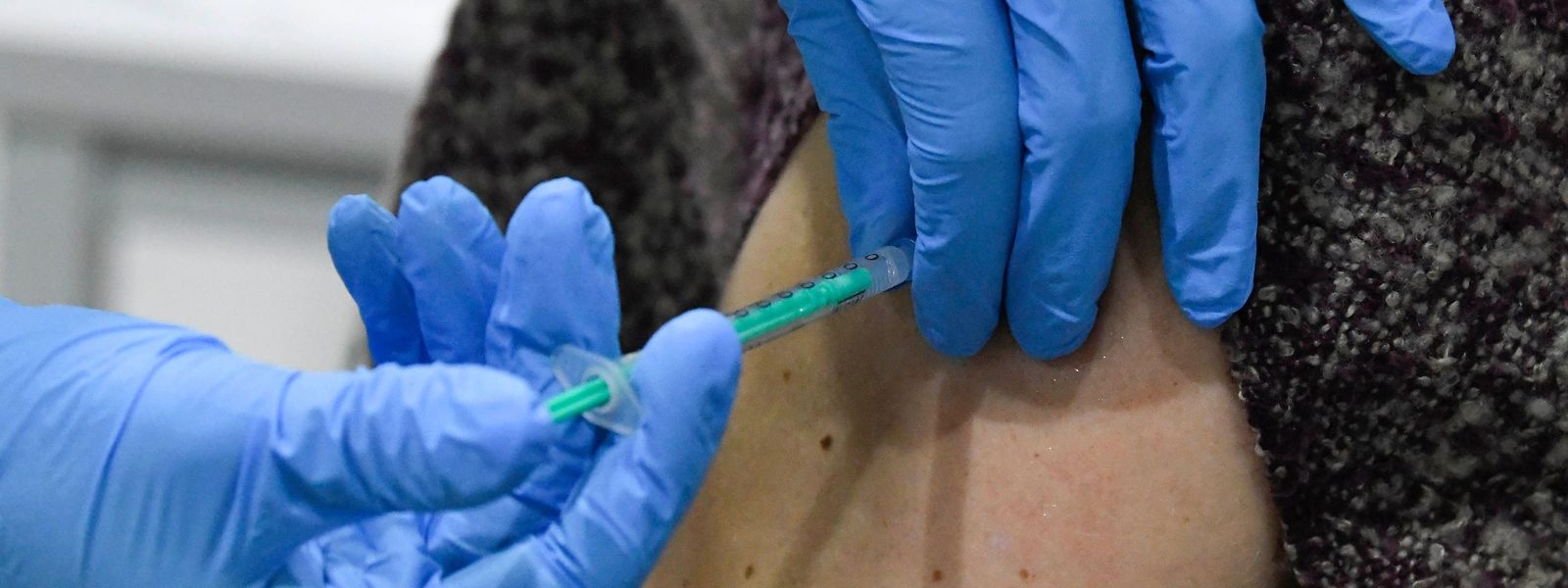 A woman receives an injection with the Pfizer-BioNTech Covid-19 disease vaccine at the regional coronavirus vaccination centre in Ludwigsburg, southern Germany, on January 22, 2021. (Photo by THOMAS KIENZLE / AFP)