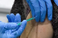 A woman receives an injection with the Pfizer-BioNTech Covid-19 disease vaccine at the regional coronavirus vaccination centre in Ludwigsburg, southern Germany, on January 22, 2021. (Photo by THOMAS KIENZLE / AFP)