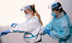Nursing students desinfect each other at the Covid-19 testing facility on the Spoor Oost site in Antwerp, on November 3, 2020. - Belgium is in a second lockdown as hospitalisations of COVID-19 patients reach record highs. (Photo by DIRK WAEM / Belga / AFP) / Belgium OUT