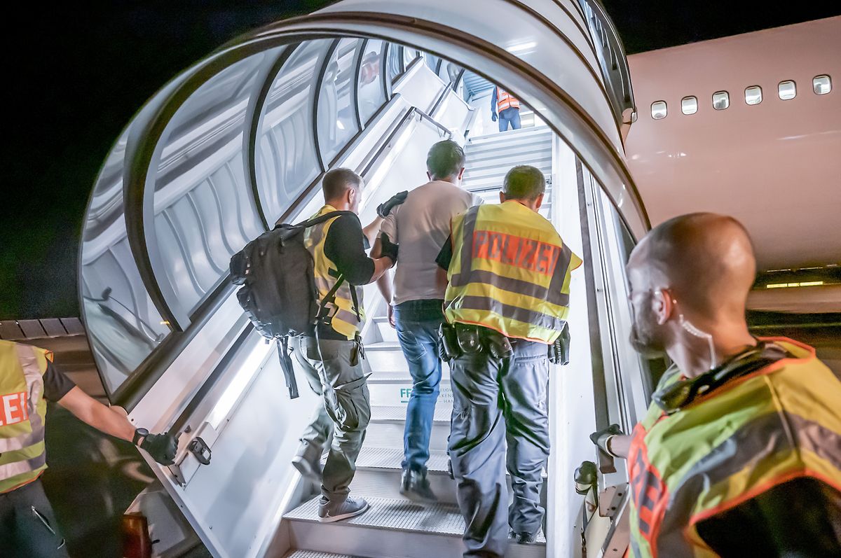 30.07.2019: Polizeibeamte begleiten einen Afghanen auf dem Flughafen Leipzig-Halle in ein Charterflugzeug. Deutschland schiebt vorerst keine Menschen mehr nach Afghanistan ab.