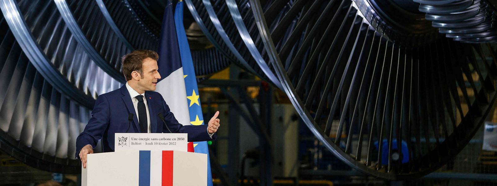 Symbolisch: Macron am Rednerpult vor einer Dampfturbine in Belfort.