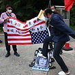 A pro-Beijing protester kicks a sign with a portrait of Nancy Pelosi, in a protest outside the American consulate in Hong Kong.