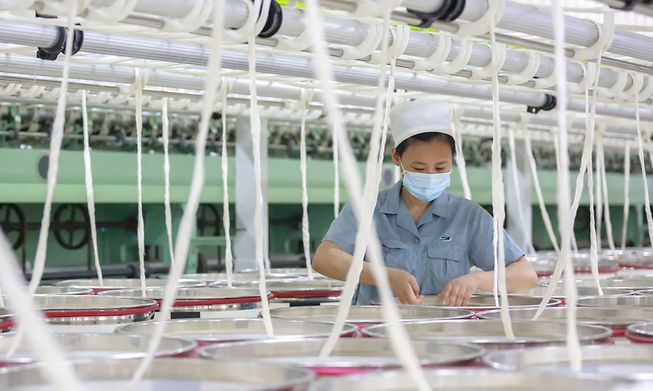 An employee works at a textile factory in China's eastern Anhui province on 7 August 