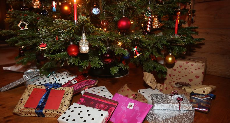 ARCHIV - 24.12.2020, Bayern, Kaufbeuren: Verpackte Weihnachtsgeschenke liegen in einem Wohnzimmer unter einem geschmückten Weihnachtsbaum. (zu dpa: Umfrage: Verbraucher befürchten Verteuerung von Weihnachtsgeschenken) Foto: Karl-Josef Hildenbrand/dpa +++ dpa-Bildfunk +++
