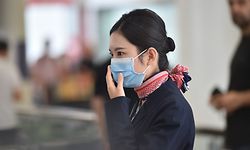 A China Eastern Airlines aircrew member arrives at Sydney airport after landing on a plane from the Chinese city of Wuhan on January 23, 2020. - One of the last flights out of the epidemic-hit Chinese city of Wuhan was met by biosecurity officials on its arrival in Sydney but no ill passengers were found, health officials said. (Photo by PETER PARKS / AFP)