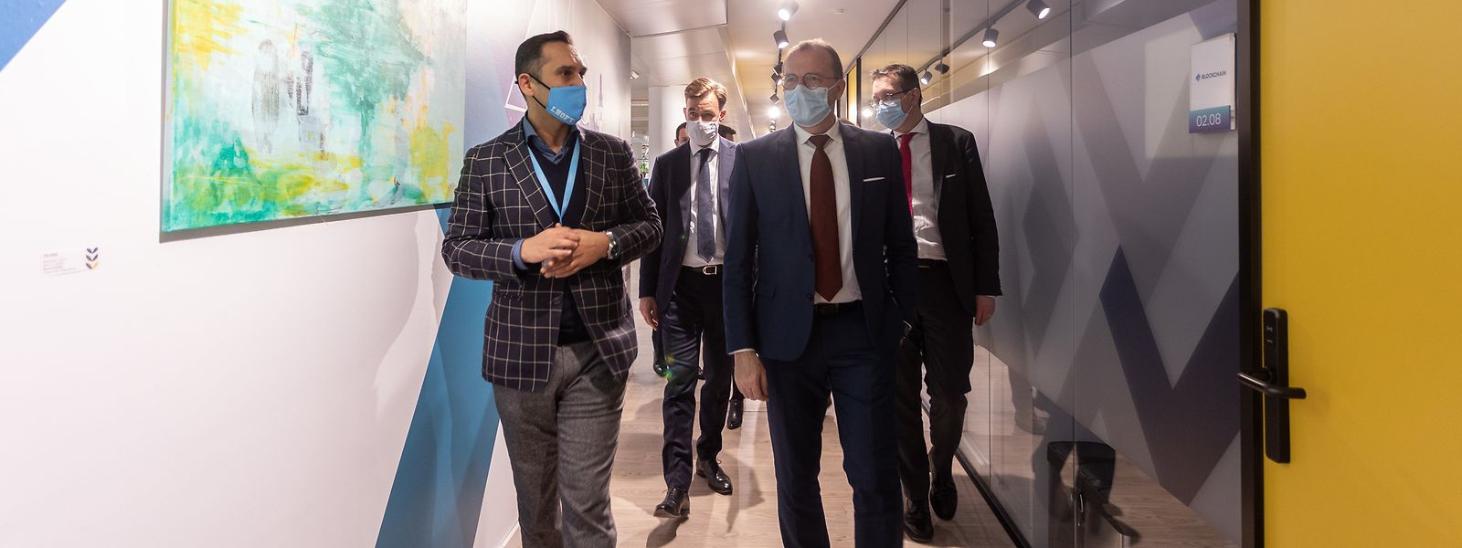 Nasir Zubairi, Chef des Luxembourg House of Financial Technology (LHoFT) führt die Minister durch die Räumlichkeiten.