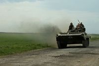 Militares ucranianos num veículo blindado numa estrada perto da aldeia de Petrivske, na região de Kharkiv.