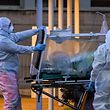 TOPSHOT - Medical workers in overalls stretch a patient under intensive care into the newly built Columbus Covid 2 temporary hospital to fight the new coronavirus infection, on March 16, 2020 at the Gemelli hospital in Rome. (Photo by ANDREAS SOLARO / AFP)