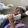 A health worker (L) wearing a Personal Protective Equipment (PPE) suit collects a swab sample from a woman to test for the Covid-19 coronavirus at a primary health centre in Hyderabad on September 3, 2020. (Photo by NOAH SEELAM / AFP)
