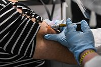 (FILES) In this file photo a woman receives a Covid-19 vaccination from Yaquelin De La Cruz at the Research Centers of America (RCA) in Hollywood, Florida, on August 13, 2020. - The Pfizer and Moderna Covid vaccines could be approved in a matter of weeks, but who in the United States will get them first? Though nothing has yet been decided, US experts may differ from other countries in prioritizing "critical workers" who keep society running -- potentially even before people at highest risk. To be clear, there won't be one single set of rules for the whole nation. (Photo by CHANDAN KHANNA / AFP)