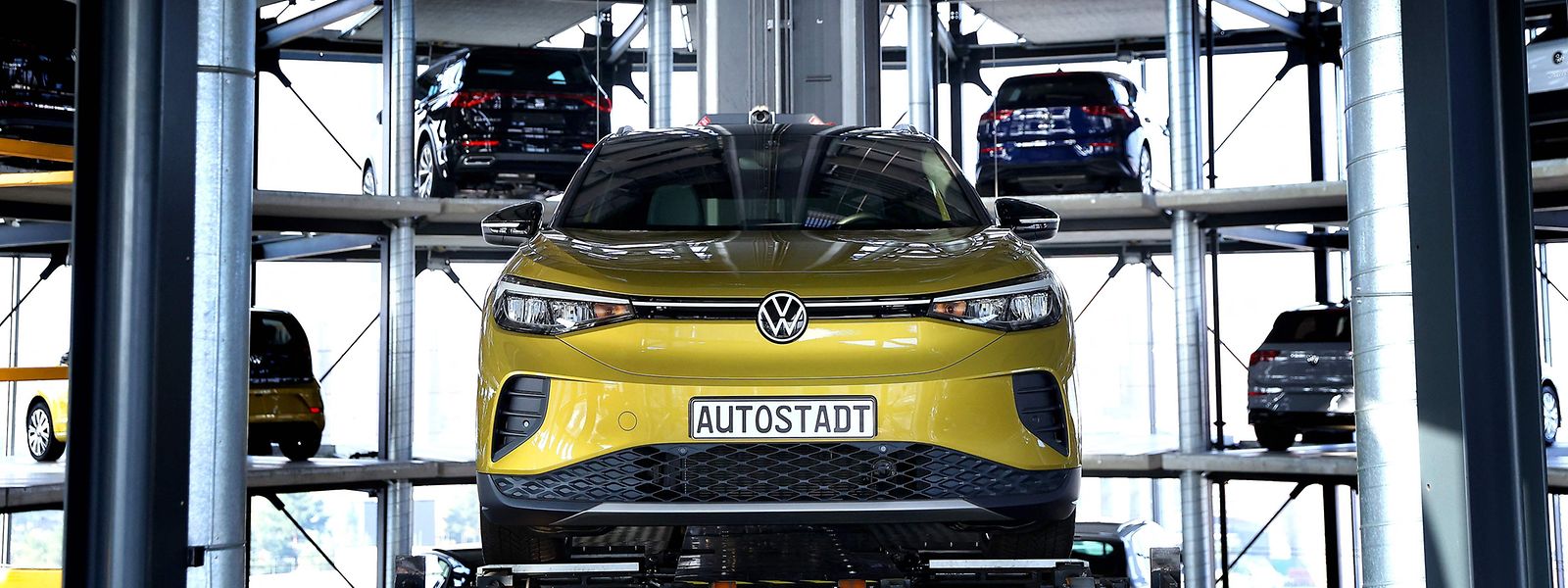 A new Volkswagen (VW) ID.4 SUV electric automobile is on display at the storage facility auto tower of German carmaker Volkswagen in Wolfsburg, northern Germany on March 26, 2021. - German auto giant Volkswagen said it is aiming to dominate the electric car market by 2025 as it accelerates the pace to catch up with US pioneer Tesla. Volkswagen sold 422,000 electrified vehicles in 2020. Of those, 230,000 were fully electric cars -- or three times more than in 2019 -- and the remainder petrol-electric hybrids. (Photo by Ronny Hartmann / AFP)