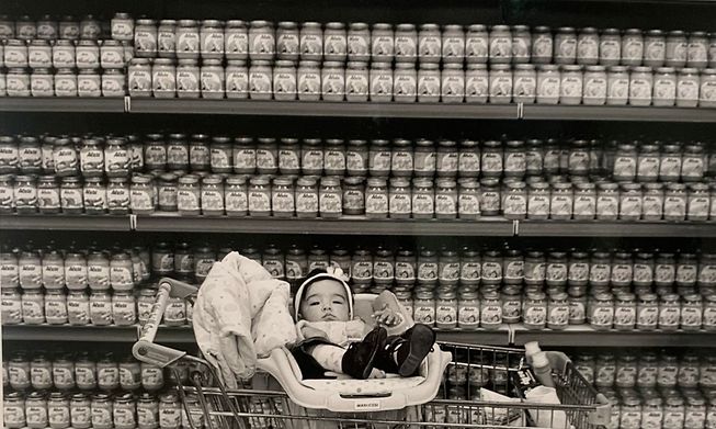 One of the photos in the exhibition shows a baby on a supermarket trolley