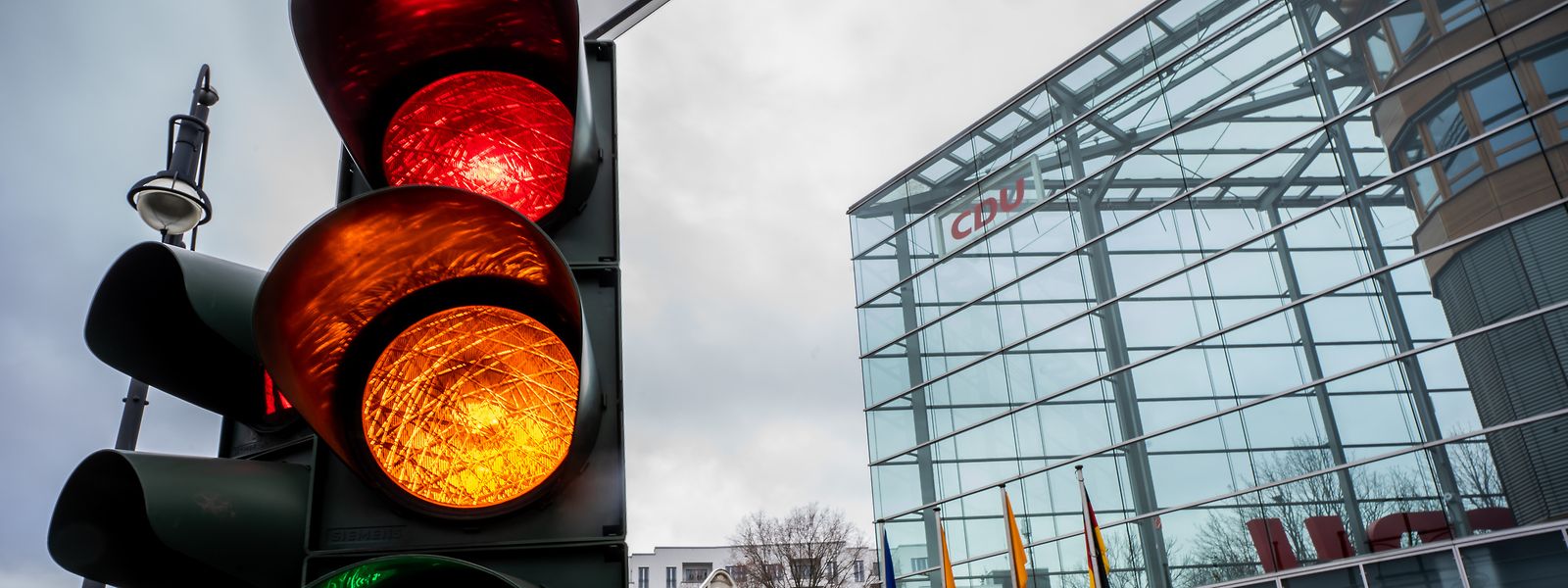 Eine Ampel vor der Bundeszentrale der CDU dem Konrad-Adenauer-Haus schaltet von Rot auf Grün.