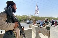 TOPSHOT - Taliban fighters stand guard at an entrance gate outside the Interior Ministry in Kabul on August 17, 2021. (Photo by Javed Tanveer / AFP)
