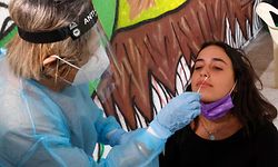 A staff member from the Israeli Sheba Medical Center uses a swab to take a sample from a student for a coronavirus test at the Herzliya Hebrew Gymnasium Hight School in the coastal city of Tel Aviv on November 8, 2020, as part of a special program that could enable students to return to school faster than planned. - The program that was launched today, involves as a first step, the screening of students and staff members with a serological test, in search for antibodies. 
After that, they will be screened three times per week using a rapid antigen test to determine if they are positive for coronavirus. (Photo by JACK GUEZ / AFP)