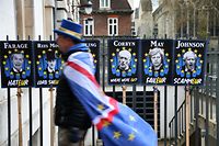 TOPSHOT - Anti-Brexit campaigner Steve Bray walks past posters featuring British politicians in Westminster, central London on April 2, 2019. - British Prime Minister Theresa May chairs a crucial meeting of senior ministers on Tuesday to seek a way out of a months-long Brexit deadlock, as the EU warned a no-deal departure from the bloc is growing more likely by the day. (Photo by ISABEL INFANTES / AFP)