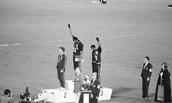 Die beiden amerikanischen Sprinter John Carlos Tommy Smith (M.) und John Carlos (r.) gehen im Oktober 1968 bei den Olympischen Spielen in Mexiko in die Geschichte ein, als sie bei der Siegerehrung zum 200-Meter-Lauf eine schwarze Faust in den Abendhimmel recken. Sie protestierten damit gegen den Vietnamkrieg und Rassismus. Als Folge werden die beiden ausgebuht und aus dem olympischen Dorf geschmissen. Aber: Die weltweite Aufmerksamkeit für ihren Protest kann ihnen aber keiner mehr nehmen.