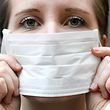 ILLUSTRATION - 28.01.2020, Österreich, Wien: Eine Frau hält einen Mundschutz vor ihrem Gesicht. Das Coronavirus hat sich bislang vor allem in China ausgebreitet. Dort gibt es schon jetzt Dutzende Todesopfer und Tausende Infizierte. Auch in Europa sind bestätigte Erkrankungen bekannt. Foto: Hans Klaus Techt/APA/dpa +++ dpa-Bildfunk +++