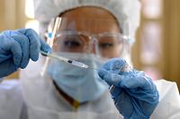 A health worker prepares a dose of the Russian Sputnik V vaccine to inoculate people over 60 years of age against the novel coronavirus disease, COVID-19, at the Faculty of Medicine of the Higher University of San Andres (USMA) in La Paz on April 27, 2021. (Photo by Jorge BERNAL / AFP)