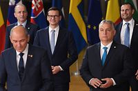 Poland's Prime Minister Mateusz Morawiecki (C) and Hungary's Prime Minister Viktor Orban (R) pose for a family photograph with EU leaders on the first day of a European Union (EU) summit at The European Council Building in Brussels on October 21, 2021. (Photo by JOHN THYS / AFP)