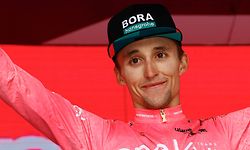 New overall leader Team Bora's Australian rider Jai Hindley celebrates on the podium after the 20th stage of the Giro d'Italia 2022 cycling race, 168 kilometers from Belluno to Marmolada (Passo Fedaia) on May 28, 2022. (Photo by Luca Bettini / AFP)