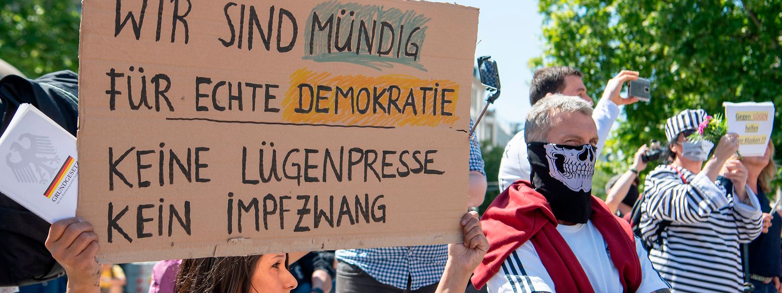 Gegen die "Lügenpresse" und einen "Impfzwang" richtet sich die Aufschrift auf dem Plakat einer Frau, die sich vor der Alten Oper in Frankfurt an einer Kundgebung gegen die Corona-Maßnahmen der Regierung richtete.