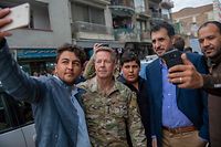 In this handout photo taken and released by Afghanistan's Ministry of Defence office on February 26, 2020, men take 'selfie' with their smartphones to pose with Commander of US and NATO forces in Afghanistan General Austin Scott Miller (2L), and with Afghanistan's Acting Defence Minister Asadullah Khalid (2R), in the city of Kabul. (Photo by HANDOUT / Afghanistan's Ministry of Defence office / AFP) / RESTRICTED TO EDITORIAL USE - MANDATORY CREDIT "AFP PHOTO / Afghanistan's Ministry of Defence" - NO MARKETING - NO ADVERTISING CAMPAIGNS - DISTRIBUTED AS A SERVICE TO CLIENTS