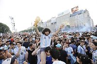Fans of Argentina celebrate their team's victory after the Qatar 2022 World Cup semifinal football match between Croatia and Argentina at the Obelisk in Buenos Aires on December 13, 2022. (Photo by Emiliano Lasalvia / AFP)