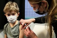 A child receives a dose of the Pfizer/BioNTech vaccine against Covid-19, in Paris, on December 17, 2021. - France's President said on December 15, 2021 that the vaccination of children against Covid-19 was "desirable" but ruled out an obligation, believing that it was the "choice of parents" adding that "Between 5 and 11 years, the health authorities have explained that it would protect, "and therefore I think it is desirable. (Photo by GEOFFROY VAN DER HASSELT / AFP)