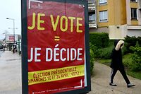 A pedestrian walks past a poster reading "I vote = I decide", calling for people to vote in the French presidential election on April 8, 2022 in the Paris suburb of Ris-Orangis. - French voters head to the polls on April 10 and 24 for a two-round pesidential election. (Photo by Emmanuel DUNAND / AFP)
