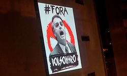 TOPSHOT - View of a projection depicting Brazil's President Jair Bolsonaro which reads "Bolsonaro Out" as part of daily protests called "Panelacos", during the outbreak of the novel coronavirus COVID-19 in Rio de Janeiro, Brazil, on March 26, 2020. (Photo by Mauro PIMENTEL / AFP)