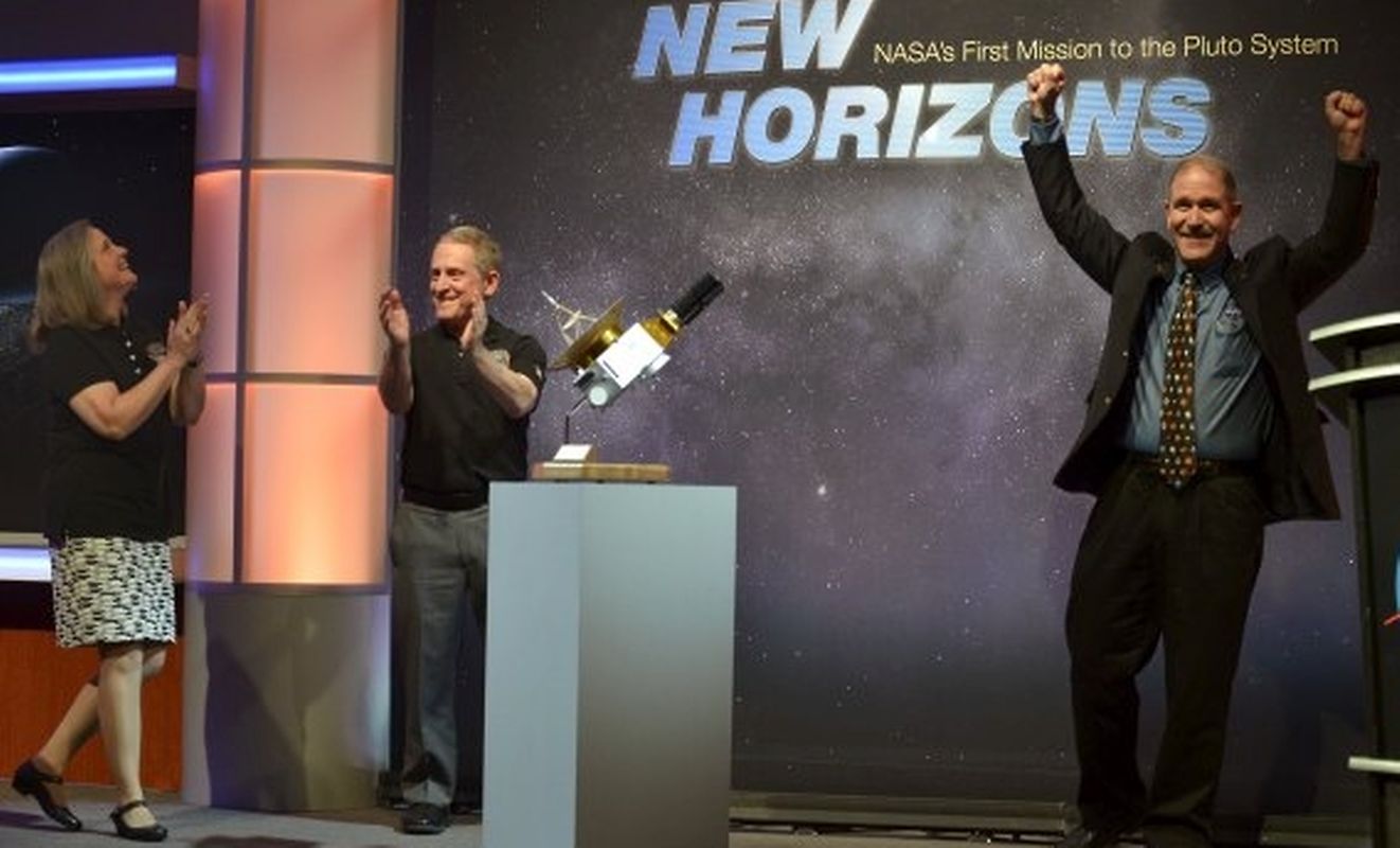 Der Leiter der "New Horizon"-Mission Alan Stern (M.) freut sich zusammen mit dem beigeordneten Administrator John Grunsfeld (r.) und dem Operationsmanager der Mission Alice Bowman.