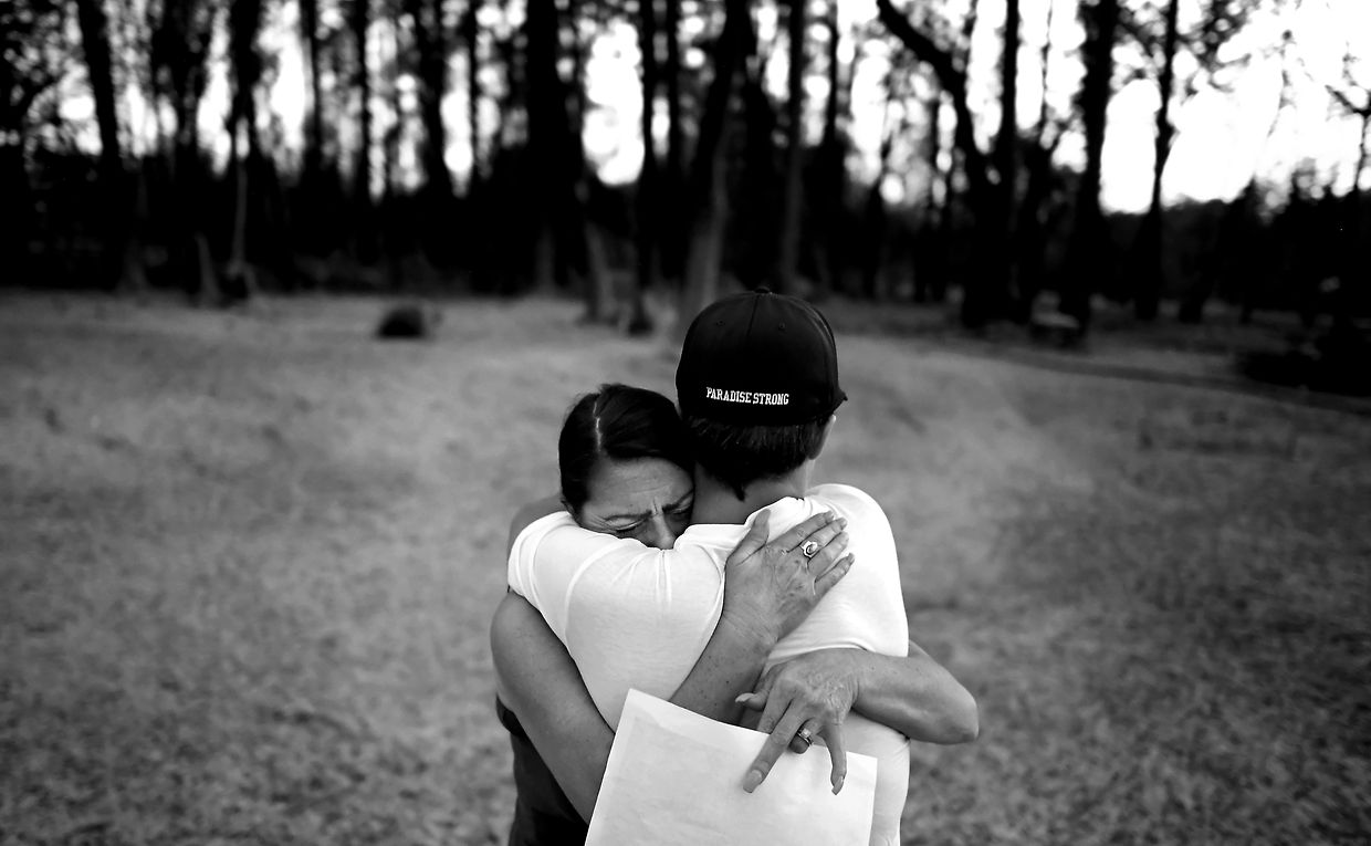 Emmie Morgan et son fils Setson, un joueur des Bobcats de Paradis se réconfortent mutuellement en visitant l'endroit où se trouvait leur maison. La photo a été prise à Paradise, aux États-Unis.