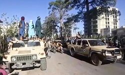 This screengrab taken from video from AFPTV shows armed members of the Taliban standing on a military vehicle in the streets of Herat, Afghanistan's third biggest city, after government forces pulled out the day before following weeks of being under siege. (Photo by STR / AFPTV / AFP)