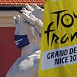 The logo of the 2020 Tour de France is seen next to a masked statue in the French Riviera city of Nice on August 26, 2020. - The 2020 edition of the Tour de France kicks off in Nice on August 29 and runs to September 20, postponed from June 27 to July 19 due to the coronavirus pandemic. (Photo by Kenzo Tribouillard / AFP)