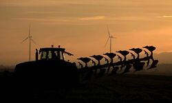 A French farmer drives a tractor as he ploughs a field in front of power-generating windmill turbines on a wind park in Vauvillers, near Amiens, in France, November 23, 2015. Paris will host the World Climate Change Conference 2015 (COP21) from November 30 to December 11.       REUTERS/Pascal Rossignol
