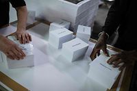 Employees pack voting ballots reading "Valerie Pecresse" for the 2022 French presidential election at a printing house in Compiegne, northern France on March 10, 2022. - The first round of the French presidential election is to take place on April 10, 2022, the second one on April 24. (Photo by JULIEN DE ROSA / AFP)