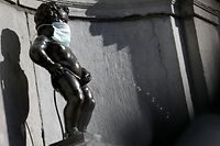 This picture taken on March 25, 2020 shows Manneken-Pis statue that wears a protective mask support of medical workers in Brussels, Belgium, 25 March 2020, as a strict lockdown comes into effect to stop the spread of the COVID-19, the disease caused by the novel coronavirus (Photo by Aris Oikonomou / AFP)