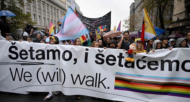 LGBT activists hold a banner as they march during a pride march, in Belgrade, on September 17, 2022. - The situation was tense on September 17, 2022, in Belgrade where representatives of the LGBTQ community vowed to march despite a ban on a Europride march by the authorities, raising fears of potential unrest. (Photo by Andrej ISAKOVIC / AFP)