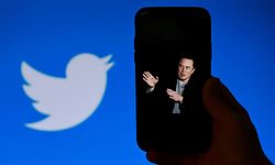 (FILES) In this file photo taken on October 4, 2022, a phone screen displays a photo of Elon Musk with the Twitter logo shown in the background, in Washington, DC. - A landslide of Twitter users responding to an informal poll by new owner Elon Musk voted in favor of a general amnesty for suspended accounts on the platform. The "yes/no" informal poll comes as Musk faces pushback that his criteria for content moderation is subject to his personal whim, with reinstatements decided for certain accounts and not others. Of 3.16 million respondents to Musk's tweeted poll question, 72.4 percent said Twitter should allow suspended accounts back on Twitter as long as they have not broken laws or engaged in "egregious spam," Musk posted. (Photo by OLIVIER DOULIERY / AFP)