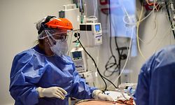 Health workers attend a COVID-19 patient at the Intensive Care Unit of the El Cruce - Dr Nestor Kirchner hospital in Florencio Varela, Argentina on April 13, 2021. (Photo by RONALDO SCHEMIDT / AFP)