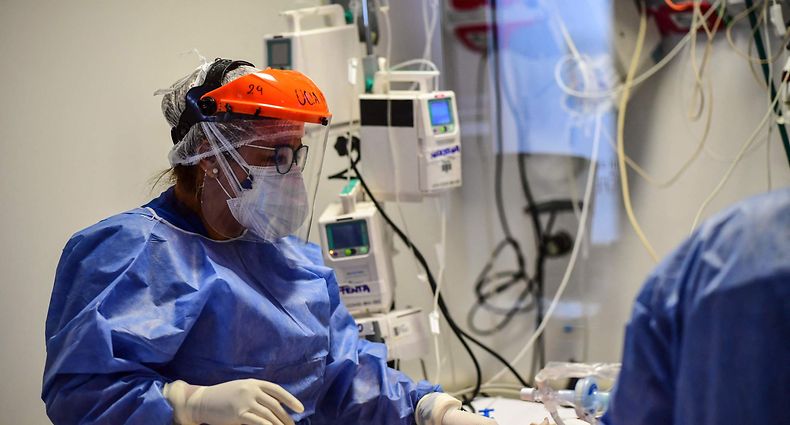 Health workers attend a COVID-19 patient at the Intensive Care Unit of the El Cruce - Dr Nestor Kirchner hospital in Florencio Varela, Argentina on April 13, 2021. (Photo by RONALDO SCHEMIDT / AFP)