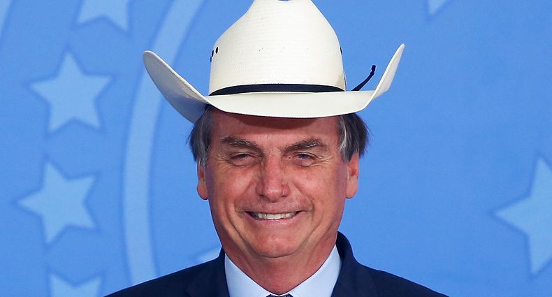 (FILES) In this file photo taken on January 29, 2020, Brazil's President Jair Bolsonaro gestures wearing a hat during a ceremony with singers of country music at Planalto Palace in Brasilia. - The outgoing Brazilian president Jair Bolsonaro, beaten in all the polls by his sworn enemy Lula, says he is sure of his victory in the first round of the October 2, 2022 election after four years of a mandate marked by crises. (Photo by Sergio LIMA / AFP)
