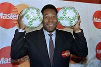(FILES) In this file photo taken on April 01, 1992 Former Brazilian soccer star, Edson Arantes do Nascimento, known as Pel� (L), holds soccer balls at an appearance to promote his tie with a creit card company that is a sponsor of the 1994 World Cup, in New York. - Brazilian football icon Pele, widely regarded as the greatest player of all time and a three-time World Cup winner who masterminded the 'beautiful game', died on December 29, 2022 at the age of 82, after battling kidney problems and colon cancer. (Photo by Maria R. BASTONE / AFP)