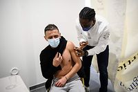 A man receives a dose of a vaccine against the Covid-19 in a social centre of La Gavotte Peyret popular neighbourhood, in Septeme-Les-Vallons, near Marseille, on January 12, 2022. - An operation is carried out by the Association Sept which encourages people to protect themselves against Covid-19 by following protective measures, distributing self-test kits and encouraging them to get vaccinated. The neighbourhoods in the north of Marseille has one of the lowest vaccination rates in France. (Photo by CLEMENT MAHOUDEAU / AFP)