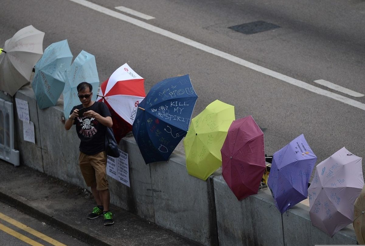 A man stands near umbrellas displayed on a road during a protest near the Hong Kong government headquarters on October 2, 2014. Hong Kong has been plunged into the worst political crisis since its 1997 handover as pro-democracy activists take over the streets following China's refusal to grant citizens full universal suffrage. AFP PHOTO / DALE DE LA REY