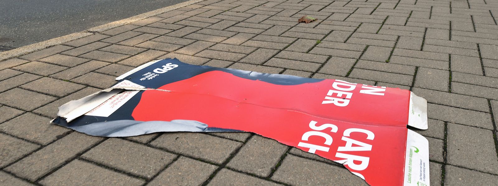 Der abgerissene Teil eines SPD-Wahlplakates liegt auf einem Fußweg. Die Parteien in Thüringen berichteten von vielen zerstörten oder entwendeten Wahlplakaten.